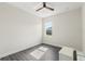 Bright bedroom with gray wood floors, ceiling fan, and window at 8977 Players Dr, Brooksville, FL 34613
