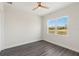 Bedroom showcasing a large window and modern ceiling fan, offering natural light and comfortable air circulation at 8977 Players Dr, Brooksville, FL 34613