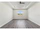 Bright bedroom featuring dark floors and large windows offering views of the surrounding landscape at 8977 Players Dr, Brooksville, FL 34613
