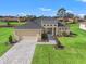 Charming single-Gathering home featuring manicured lawns, a two-car garage, and a welcoming walkway at 8977 Players Dr, Brooksville, FL 34613