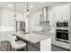 Modern kitchen featuring stainless steel appliances, gray cabinets, quartz countertops, and stylish pendant lighting at 8977 Players Dr, Brooksville, FL 34613