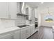 Well-lit kitchen featuring modern appliances, custom backsplash, and a view to the dining room at 8977 Players Dr, Brooksville, FL 34613