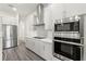 Bright kitchen featuring stainless steel appliances and gray cabinets with stylish tile backsplash at 8977 Players Dr, Brooksville, FL 34613
