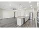 Open concept kitchen and living room with stainless steel appliances and island with sink at 8977 Players Dr, Brooksville, FL 34613