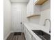 Laundry room with white cabinets, quartz countertops, and stainless steel sink at 8977 Players Dr, Brooksville, FL 34613