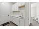 Bright laundry room features white cabinets, countertops, and stainless sink at 8977 Players Dr, Brooksville, FL 34613