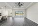 Spacious living room features hardwood floors, tray ceiling, fan, and outdoor access at 8977 Players Dr, Brooksville, FL 34613