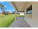 Covered patio with brick pavers offers serene views of the backyard at 8977 Players Dr, Brooksville, FL 34613