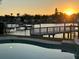 Tranquil waterfront view from the pool, featuring docks and a vibrant sunset at 1118 Monterey Ne Blvd, St Petersburg, FL 33704