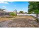 Fenced-in backyard with a screened-in pool, mature trees, and a large grassy area at 1240 Ridgegrove S Dr, Palm Harbor, FL 34683