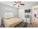Cozy bedroom featuring a ceiling fan, closet, mounted TV, and wood-look floors at 1240 Ridgegrove S Dr, Palm Harbor, FL 34683