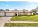 Charming single Gathering home with a well-maintained lawn and inviting front entrance, and two-car garage at 1240 Ridgegrove S Dr, Palm Harbor, FL 34683