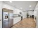 Modern eat-in kitchen features stainless steel appliances, sleek white cabinetry, and updated flooring at 1240 Ridgegrove S Dr, Palm Harbor, FL 34683