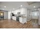 Spacious kitchen with stainless steel appliances, granite countertops, white cabinets, and wood-look flooring at 1240 Ridgegrove S Dr, Palm Harbor, FL 34683