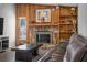Cozy living room featuring a stone fireplace, wood paneled walls, and a comfortable leather couch at 1240 Ridgegrove S Dr, Palm Harbor, FL 34683