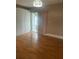 Bedroom featuring hardwood floors and view of window with vertical blinds at 1811 Bedford Ln # 162, Sun City Center, FL 33573