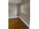 A simple bedroom features hardwood floors and a window with blinds for natural light at 1811 Bedford Ln # 162, Sun City Center, FL 33573