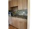 A kitchen counter with wood cabinets, hardware, and a speckled granite countertop at 1811 Bedford Ln # 162, Sun City Center, FL 33573