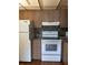 Bright kitchen featuring ample wood cabinets and white appliances, including an oven and refrigerator at 1811 Bedford Ln # 162, Sun City Center, FL 33573