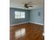 Spacious living room featuring wood floors, a window with blinds, and light blue walls at 1811 Bedford Ln # 162, Sun City Center, FL 33573