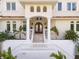 Elegant home entrance featuring a grand staircase, wrought iron doors, and manicured landscaping at 1855 Bayou Grande Ne Blvd, St Petersburg, FL 33703