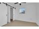 Minimalist bedroom with sliding barn doors, a window, and a ceiling fan at 2540 W Pine St, Tampa, FL 33607