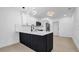 Kitchen island with waterfall countertop, white cabinets, stainless appliances and unique light fixtures at 2540 W Pine St, Tampa, FL 33607