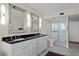 Bathroom featuring double sinks with black countertops, large mirrors, and a glass-enclosed shower at 3301 Bayshore Blvd # 1908B, Tampa, FL 33629