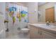 A bathroom featuring a world map shower curtain and neutral toned cabinets at 4010 N Lockwood Ridge Rd, Sarasota, FL 34234