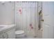 Functional bathroom featuring a toilet, sink, and a shower with a floral-patterned curtain at 4010 N Lockwood Ridge Rd, Sarasota, FL 34234