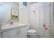 Clean bathroom with a sink, toilet, and a shower enclosed by a white floral shower curtain at 4010 N Lockwood Ridge Rd, Sarasota, FL 34234