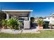 Carport with mature landscaping, featuring a parked car and air conditioning unit at 4010 N Lockwood Ridge Rd, Sarasota, FL 34234