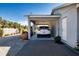 Carport with a parked car, surrounded by potted plants and a well-maintained gravel area at 4010 N Lockwood Ridge Rd, Sarasota, FL 34234