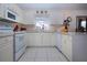 Well-lit kitchen featuring white cabinetry, appliances, and a view from over the sink at 4010 N Lockwood Ridge Rd, Sarasota, FL 34234