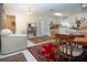 Open living room with white tile, a bright kitchen, and a cozy dining area at 4010 N Lockwood Ridge Rd, Sarasota, FL 34234