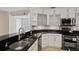 Modern kitchen featuring granite countertops, stainless steel appliances, and white cabinets at 4224 Preserve Pl, Palm Harbor, FL 34685