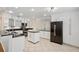 Modern kitchen with black countertops, black appliances, white cabinetry and an island prep area at 4224 Preserve Pl, Palm Harbor, FL 34685