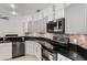 Well-appointed kitchen with stainless steel appliances, granite counters, white cabinets, and mosaic backsplash at 4224 Preserve Pl, Palm Harbor, FL 34685