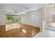 Bright living room with hardwood floors, large glass doors to outside patio, and modern ceiling fan at 4224 Preserve Pl, Palm Harbor, FL 34685
