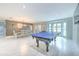 Open-concept living area with a pool table, dining set, and large windows for natural light at 4810 Centerbrook Ct, Tampa, FL 33624
