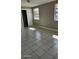 Bedroom features tiled flooring, neutral paint, and natural light from two windows at 5507 Riddle Rd, Holiday, FL 34690