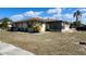 Single Gathering home featuring an enclosed patio area and a partially dry lawn at 5507 Riddle Rd, Holiday, FL 34690