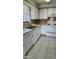 Updated kitchen with white cabinets, stainless steel sink and appliances, and tiled floor at 5507 Riddle Rd, Holiday, FL 34690