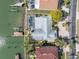 Aerial view of the property featuring a waterfront location, boat dock, pool, and mature landscaping at 5836 Skimmer Point S Blvd, Gulfport, FL 33707
