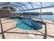 Inviting screened-in pool and hot tub with bay view, set in a paver patio for outdoor enjoyment at 5836 Skimmer Point S Blvd, Gulfport, FL 33707