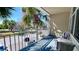 A sun drenched balcony with seating overlooks the street with beautiful landscaping and tropical palm trees in the background at 611 Destiny Dr # 604, Ruskin, FL 33570