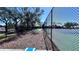 Outdoor cornhole amenity next to tennis courts surrounded by a secure black chain-link fence on a sunny day at 611 Destiny Dr # 604, Ruskin, FL 33570