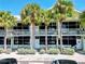A condo complex featuring balconies, large windows, fresh light green paint, and mature palm trees at 611 Destiny Dr # 604, Ruskin, FL 33570