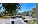 This street view offers beautiful manicured landscaping with palm trees and lush greenery, and a glimpse of the tennis courts at 611 Destiny Dr # 604, Ruskin, FL 33570