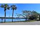Scenic waterfront view with lush greenery, palm trees, and picnic tables offering a serene environment at 611 Destiny Dr # 604, Ruskin, FL 33570
